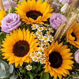 Primo piano del bouquet Raggio d'Estate con dettaglio dei petali di girasole fresco, lisianthus viola e spighe di grano.